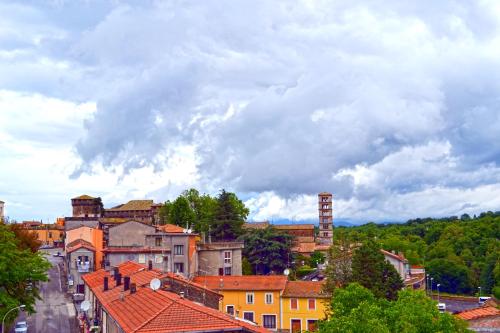 eine Gruppe von Gebäuden in einer Stadt unter einem wolkigen Himmel in der Unterkunft Ortaccio relais & private SPA in Vasanello
