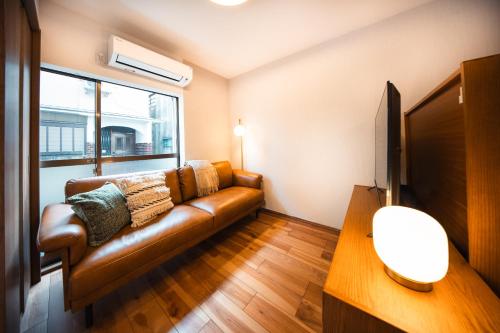 a leather couch in a living room with a window at Private House KANADE in Nara