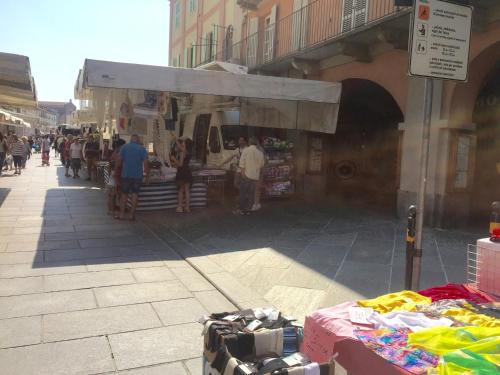 a group of people standing outside of a market at Palazzo di Città in Saluzzo