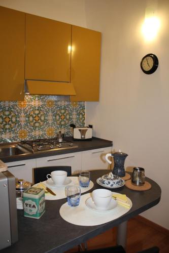 una cocina con una mesa con tazones y platos. en Casa del Girasole en Nápoles