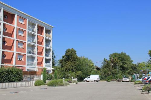 a parking lot next to a large apartment building at La Colombière - Vue imprenable sur l'Ardèche - Très Calme - Très bien situé - Résidence Privée in Montélimar