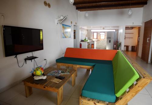 a living room with a table and a tv at Karibbik Haus Hostel in San Andrés