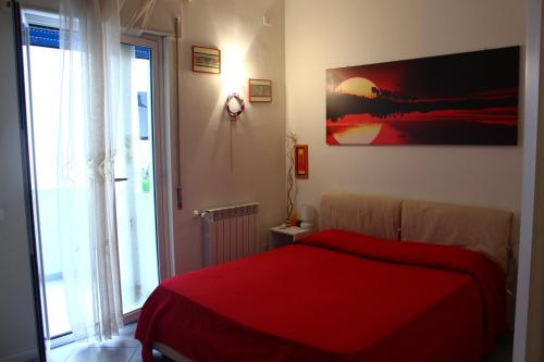 a bedroom with a red bed and a large window at Esedra B&B in Palermo