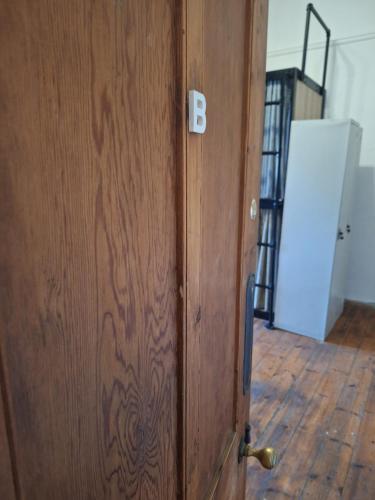 a wooden door with a letter b on it at BIM Backpackers In Muizenberg in Muizenberg