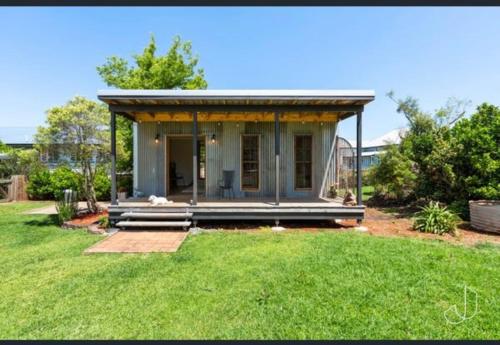 een tiny house met een veranda in een tuin bij Modern Rustic Backyard Studio Private & Cosy Retreat in Mount Tamborine