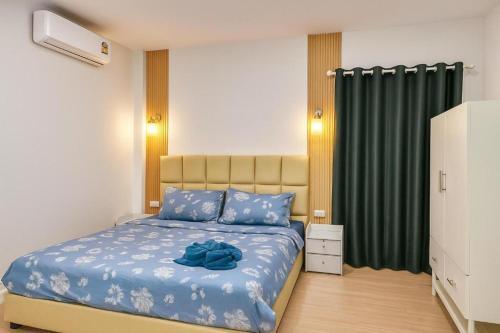 The Luang Prabang House في لوانغ برابانغ: غرفة نوم بها سرير مع لحاف أزرق