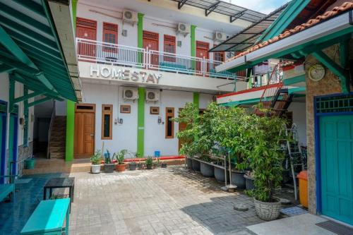 a building with a home stay sign in a courtyard at RedDoorz Syariah near Alun Alun Balai Kota Tegal in Tegal