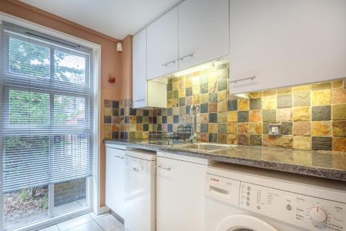 cocina con fregadero y ventana en London Tower Bridge Apartments, en Londres