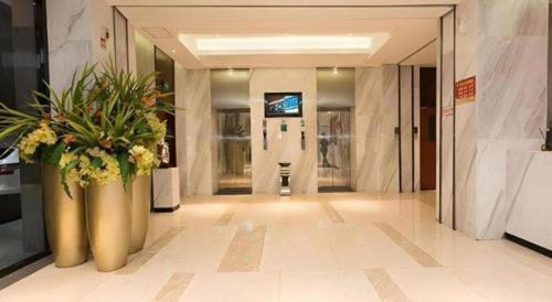 a lobby with a large vase with flowers in it at City Comfort Inn Xiangyang Railway Station in Xiangyang