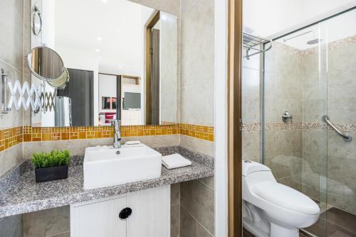 a bathroom with a sink and a toilet and a shower at Terrazas Tayrona Travelers Apartamentos y Suites in Santa Marta