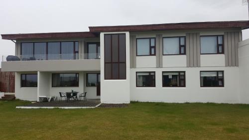 a white house with black windows and a patio at Anita´s Guest House in Grindavík
