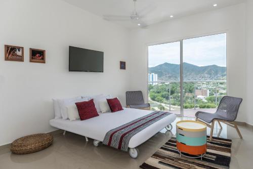 a bedroom with a bed and a large window at Terrazas Tayrona Travelers Apartamentos y Suites in Santa Marta