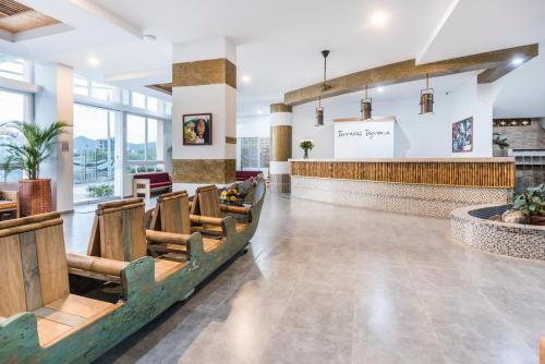 a lobby of a restaurant with chairs and a bar at Terrazas Tayrona Travelers Apartamentos y Suites in Santa Marta