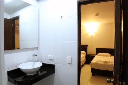 ein Bad mit einem Waschbecken und ein Bett in einem Zimmer in der Unterkunft Hotel Villa Colonial By Akel Hotels in Cartagena de Indias