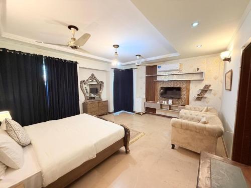 a bedroom with a bed and a couch and a fireplace at MELBERRY Guest House in Islamabad