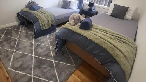 a bedroom with two beds with a dog laying on the blanket at Family Friendly - 5 Mins To Beach in Belmont
