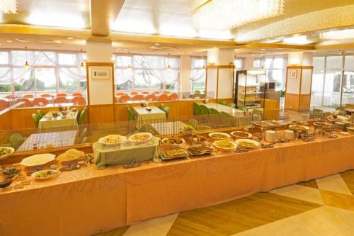 una línea de buffet con muchos platos de comida en Hotel Axia Kushikino, en Ichikikushikino