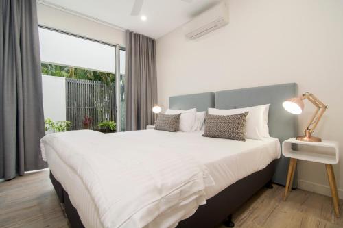 a bedroom with a large bed and a large window at Pool Resort Port Douglas in Port Douglas