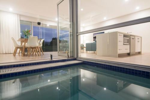 a house with a swimming pool and a kitchen at Pool Resort Port Douglas in Port Douglas