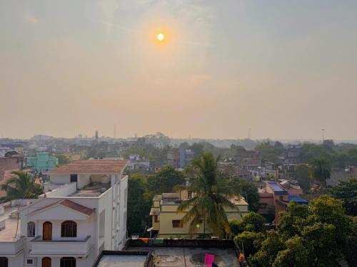 einen Blick auf eine Stadt mit der Sonne am Himmel in der Unterkunft Studio 303 Urban Luxe Micro in Deoghar