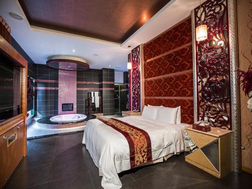 a bedroom with a large bed and a bath tub at Moon Area Motel in Douliu