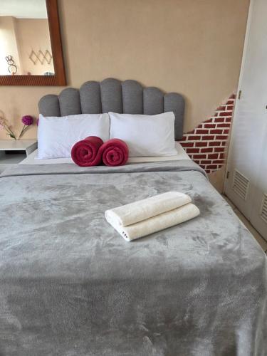 a bed with two towels and red roses on it at Apartamento 1005 Cortijo in Guatemala