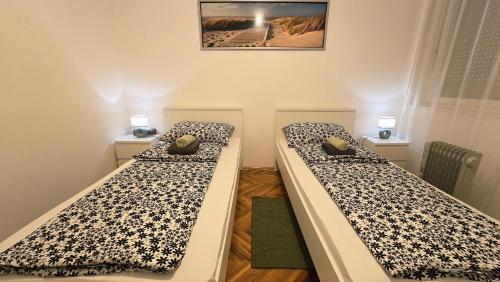 two beds in a small room with two lamps at Apartman Mik - Daruvar in Daruvar
