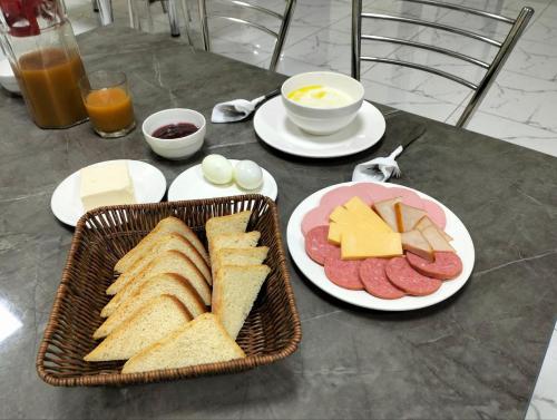 een tafel met een mand vol brood, vleeswaren en kaas bij Yangi Sergeli in Sergeli