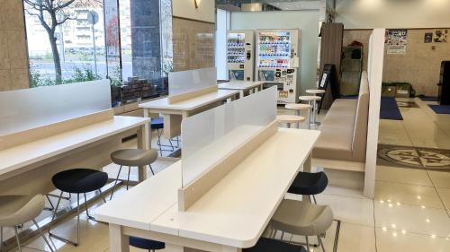 a store with white tables and stools at Toyoko Inn Hokkaido Asahikawa eki Higashi guchi in Asahikawa