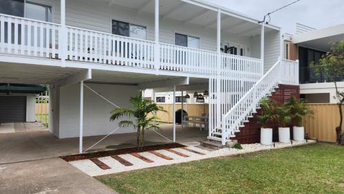 a house with a white staircase in a yard at Beach Bound-Jervis Bay in Vincentia