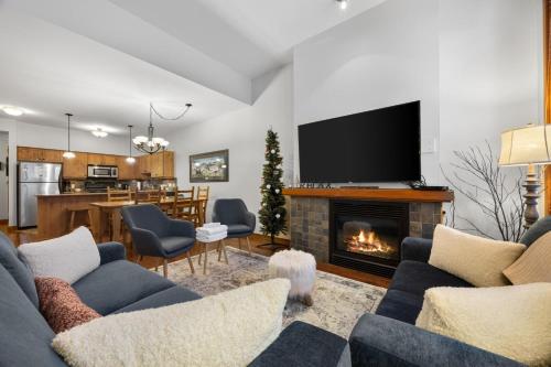 a living room with a couch and a fireplace at Settlers Crossing #29 By Bear Country in Sun Peaks