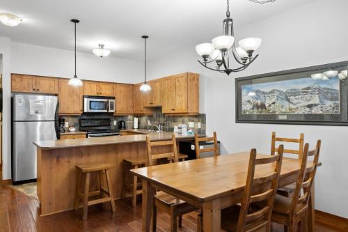 a kitchen with a wooden table and a dining room at Settlers Crossing #29 By Bear Country in Sun Peaks