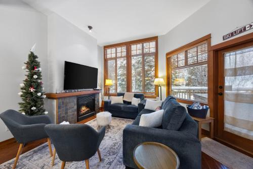 a living room with a christmas tree and a fireplace at Settlers Crossing #29 By Bear Country in Sun Peaks