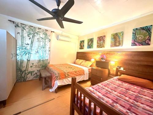 a bedroom with two beds and a ceiling fan at Kampung B&B Homestay in Kampong Pepedonkiang