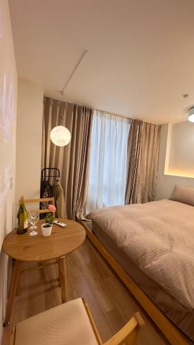 a bedroom with a bed and a table and a window at Moon Base Tokyo Inn in Tokyo