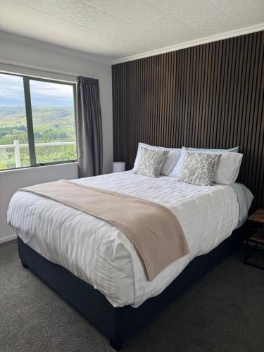 a bedroom with a large bed with a large window at Entire home in Roxburgh in Roxburgh