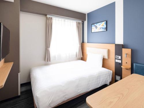 a hotel room with a bed and a window at Comfort Hotel Narita in Narita