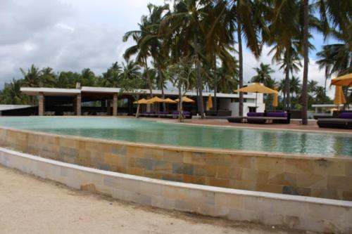 a pool with chairs and umbrellas in a resort at Anema Wellness Villa & Spa Gili Lombok - Diving Center PADI in Tanjung