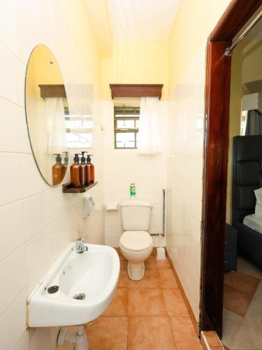 a bathroom with a white toilet and a sink at Cosy 1 BR with Swimming Pool & Garden & 25 Mins to Airport - C04 in Mombasa