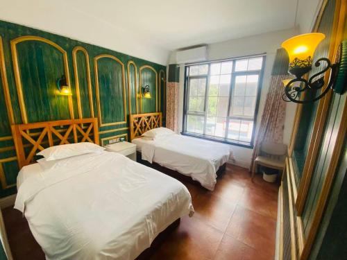 een slaapkamer met twee bedden en een raam bij Half-City Homestay in Xi'an