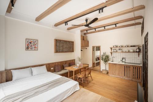 a bedroom with a bed and a table and a kitchen at Urban Horizon Boutique Suites in Hanoi