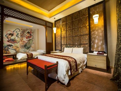 a bedroom with a large bed with a red bench at Moon Area Motel in Douliu