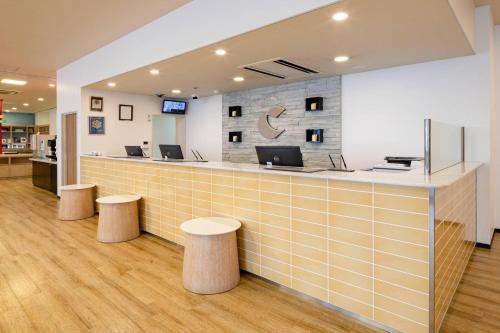 a lobby with a counter with two stools at Comfort Hotel Hamamatsu in Hamamatsu