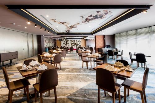 a restaurant with tables and chairs and a ceiling at The HO Hotel in Hsinchu City