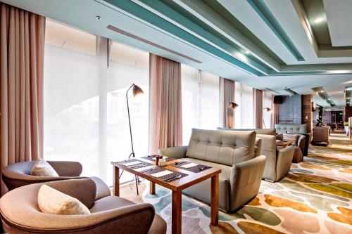 a lobby with couches and chairs and a table at The HO Hotel in Hsinchu City