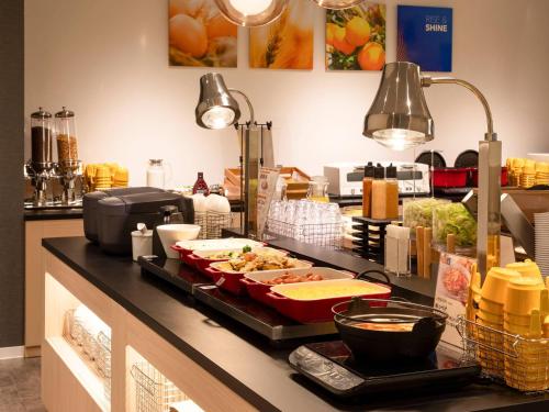 a kitchen with a buffet with food on a counter at Comfort Hotel Mito in Mito