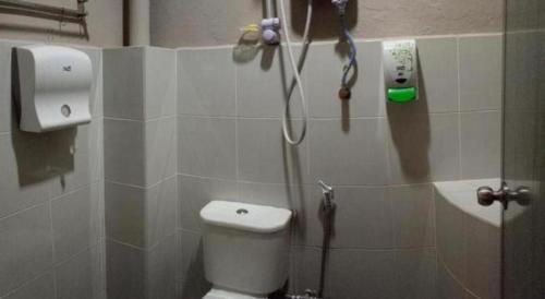 a bathroom with a shower with a toilet and a phone at History Hotel in Kangar