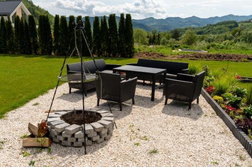 a fire pit in a backyard with chairs and a table at Zacisze Beskidu - Private House with Sauna, Jacuzzi & Pool in Łącko