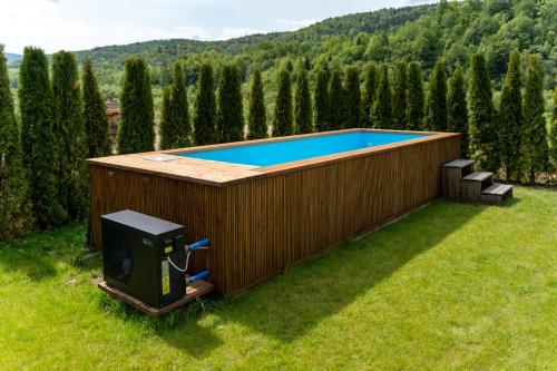 a swimming pool in a backyard with a wooden fence at Zacisze Beskidu - Private House with Sauna, Jacuzzi & Pool in Łącko