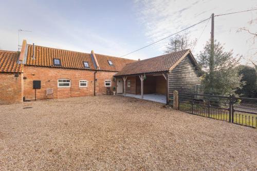 an empty driveway in front of two brick buildings at Stunning 5-bed Barn Conversion in Newark-on-Trent by Renzo, Beautiful Surroundings, Sleeps 10! in Besthorpe